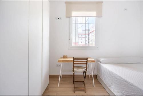 塞维利亚Acogedor y precioso apartamento en Sevilla的一间带桌子和床的小卧室