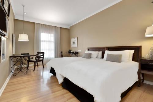 内尔斯普雷特内尔斯普雷特万豪普罗蒂亚酒店的卧室配有一张白色的大床和一张桌子