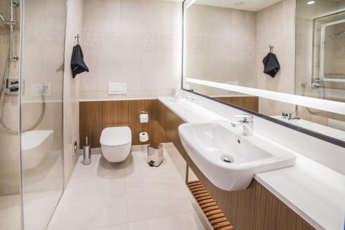 卡托维兹卡托维兹市中心万怡酒店的白色的浴室设有水槽和卫生间。
