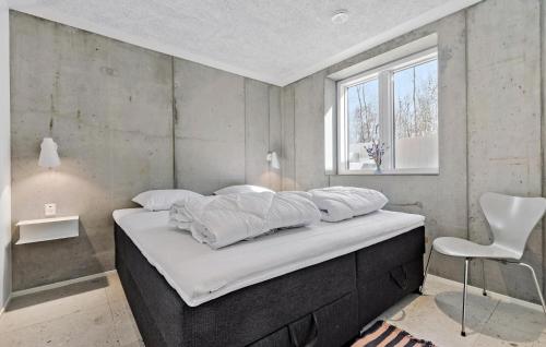 格雷诺Amazing Home In Grenaa With Kitchen的一张带白色床单的床和一把椅子