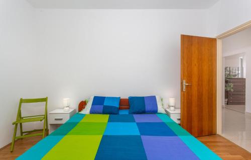 奥米沙利3 Bedroom Pet Friendly Home In Omisalj的一间卧室配有一张带彩色床罩的床