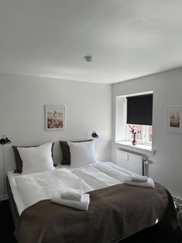 腓特烈松VISIONHOUSE Hotel的白色卧室配有一张大床和两条毛巾