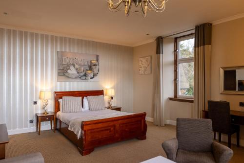 鲁阿BDL罗斯利大厅酒店的一间卧室配有一张床、两把椅子和一个窗户