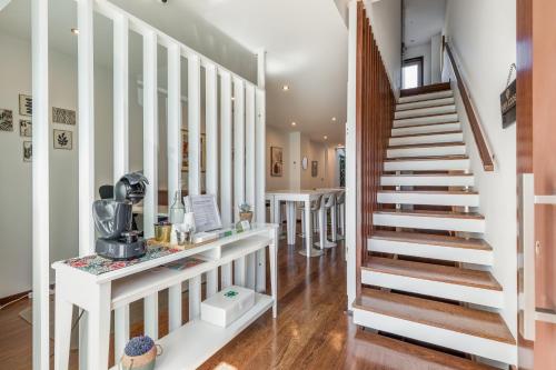 埃斯平霍Viravento - Guesthouse & Creative Space的房屋内的楼梯,拥有白色的墙壁和木地板