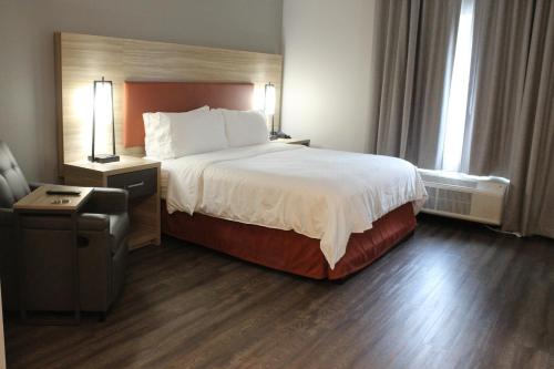纳什维尔Candlewood Suites - Nashville South, an IHG Hotel的酒店客房带一张大床和一把椅子