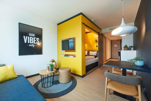 阿姆斯特尔芬Cityden Zuidas的客厅设有蓝色的沙发和黄色的墙壁
