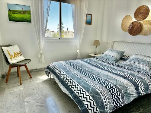 锡蒂奥卡拉翁达Bright apartment 300m from the beach的卧室配有床、椅子和窗户。
