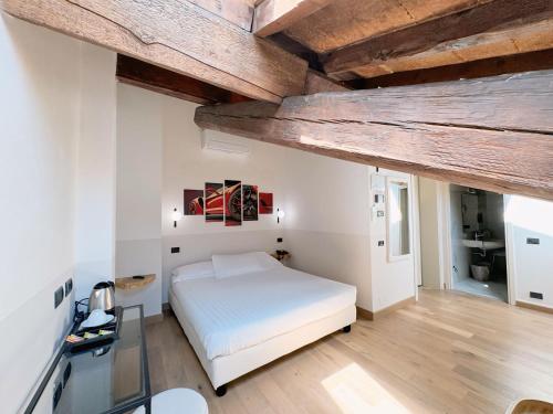 摩德纳雷齐吉公园酒店的卧室设有白色的床和木制天花板。