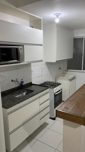尤西德福拉Park marilandia 507的厨房配有白色橱柜和炉灶烤箱。