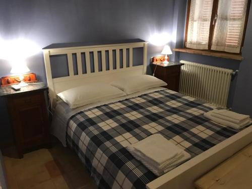 Colle San LorenzoAntico Casale San Lorenzo的一间卧室配有一张带2个床头柜的大床