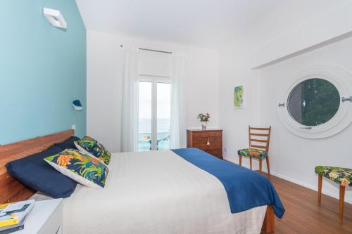 阿拉西奥La Fiorella: appartamento con terrazze in villa的一间卧室配有一张床、一张书桌和一个窗户。
