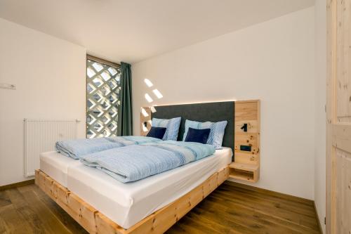 布列瑟农Untermoarhof Albeins的一间卧室配有一张带蓝色枕头的大床