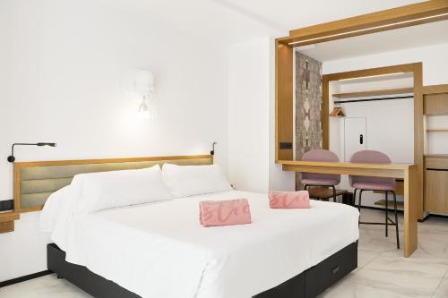 圣安东尼奥Stic Urban Hotel & SPA的卧室配有白色床和粉红色枕头。