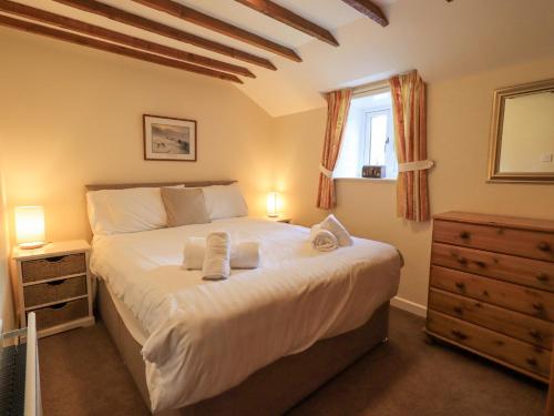 格拉斯米尔Hollens Cottage的一间卧室配有一张大床和毛巾