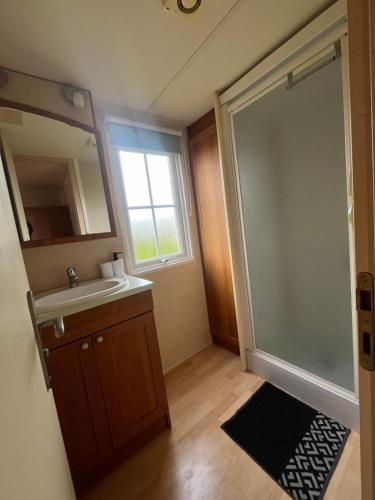 乌伊斯特勒昂Mobile-home Camping 4 etoiles bord de mer的浴室配有盥洗盆和带镜子的淋浴