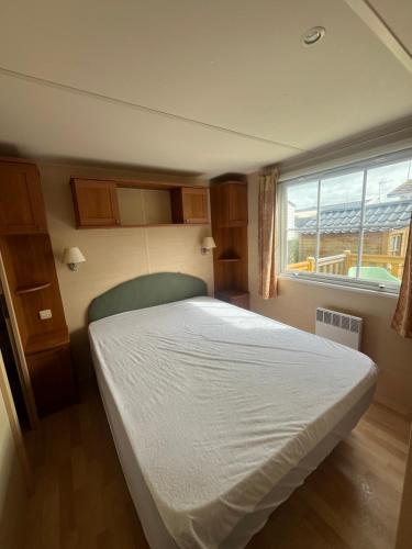 乌伊斯特勒昂Mobile-home Camping 4 etoiles bord de mer的卧室配有白色的床和窗户。
