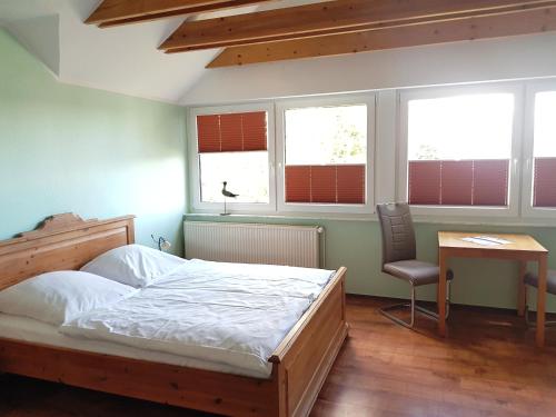 巴贝Ferienwohnungen im Haus Bi Henny的卧室配有一张床、一张书桌和窗户。