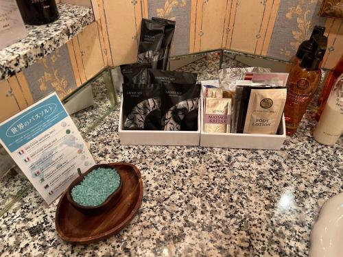 横滨尊贵花园情趣酒店（仅限成人）的浴室柜台,配有一碗肥皂和其他产品