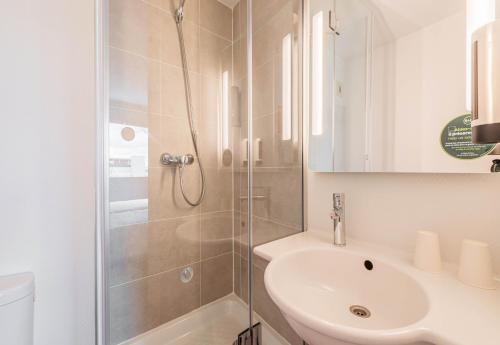 索西姆B&B HOTEL Mulhouse Sausheim的带淋浴和盥洗盆的白色浴室