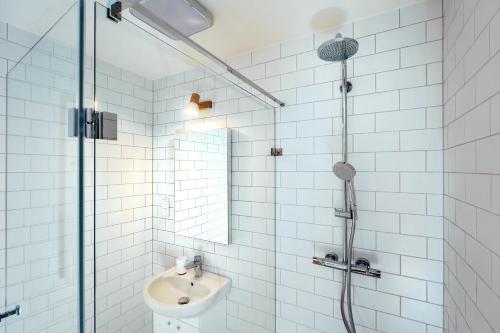 GdówDomki Kuter Port的带淋浴和盥洗盆的白色瓷砖浴室