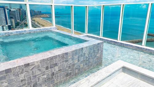 福塔莱萨斯汝普莱亚酒店的一座位于大楼顶部的游泳池,俯瞰着大海