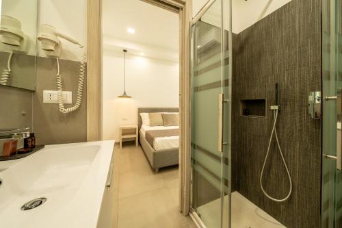 卡利亚里Poseidon Rooms的带浴缸的浴室和卧室
