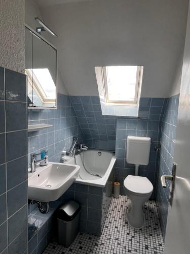 波鸿FlattyOne Ruhrgebiet - Schlafkomfort und Anbindung - neu renoviert的蓝色瓷砖浴室设有水槽和卫生间