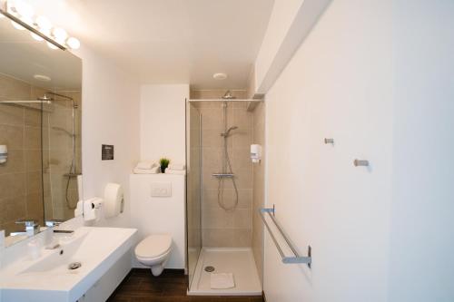 奥斯坦德艾姆巴萨德洛酒店的带淋浴、盥洗盆和卫生间的浴室