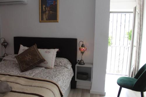 格拉纳达Apartamentos Vado - Cuesta de Alhacaba的卧室配有床、椅子和窗户。