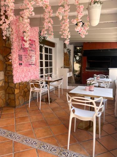 卡拉米洛bhc Boutique Hostal Cala Millor的庭院配有桌椅和粉红色的鲜花