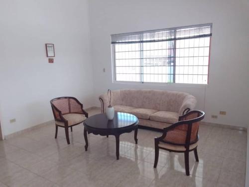 ChichirivicheCasa Nahomy的客厅配有沙发、两把椅子和一张桌子