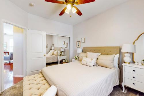 吉尔伯特Garden Breeze的卧室配有白色的床和吊扇