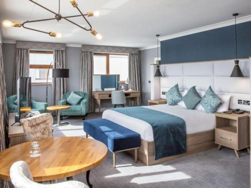 恩尼斯克朗钻石海岸酒店的酒店客房设有一张大床和一张桌子。