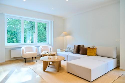 布鲁塞尔The Nations Bois de la Cambre Flats的客厅配有白色的沙发和桌子