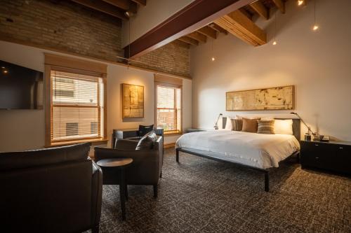 法戈唐纳森酒店的一间卧室配有一张床、一张沙发和椅子