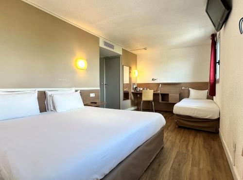 勒布尔热基里亚德布杰中央世博园酒店的酒店客房设有一张大床和一张书桌。