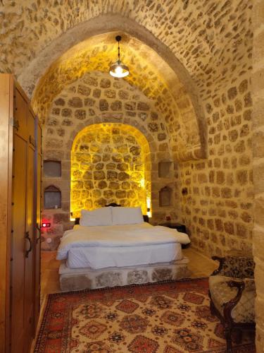 马尔丁Rumet paşa konağı的卧室配有一张石墙床
