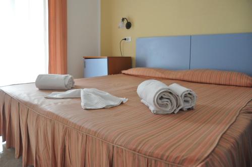 兰佩杜萨里佩拉吉耶酒店的床上配有毛巾和枕头
