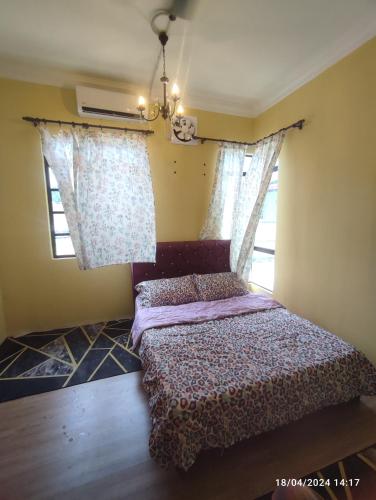 巴佐Homestay Zamzam的一间卧室设有一张床和两个窗户。