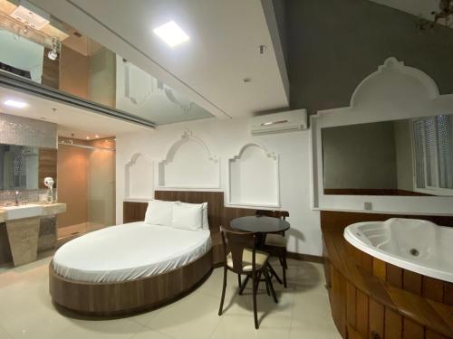 阿雷格里港Drops Motel Porto Alegre的一间卧室配有一张床,浴室设有水槽