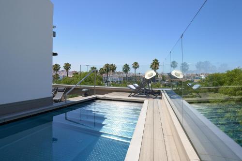 塞维利亚Hotel Kivir的建筑物屋顶上的游泳池
