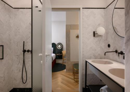 里斯本Montebelo Vista Alegre Lisboa Chiado Hotel的一间带水槽和淋浴的浴室