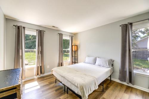 杰克逊维尔Charming Jacksonville Abode with Patio!的一间卧室设有一张床和两个窗户。