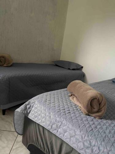 巴西利亚Apartamento 5 km do aeroporto的一间设有两张床的房间和床上的一条毛巾