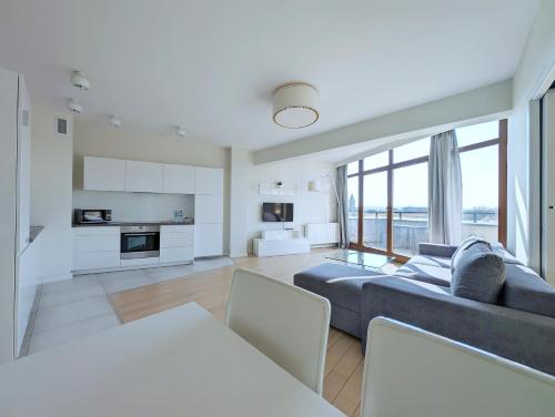克拉科夫Turnau City Aparthotel的一间带大蓝色沙发的客厅和一间厨房