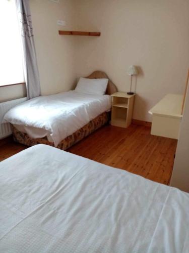 敦贝格Atlantic View的一间卧室配有两张床和一张带台灯的桌子