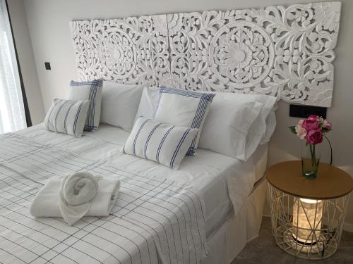 纽斯特拉塞诺拉耶苏斯WHITE HOUSE IBIZA的一张带枕头和毛巾的白色床