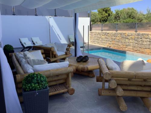 纽斯特拉塞诺拉耶苏斯WHITE HOUSE IBIZA的带沙发的客厅和游泳池