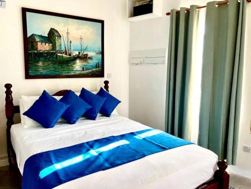 Port ElizabethModern apt with view and easy beach access的一间卧室配有一张带蓝色枕头的床和一幅画