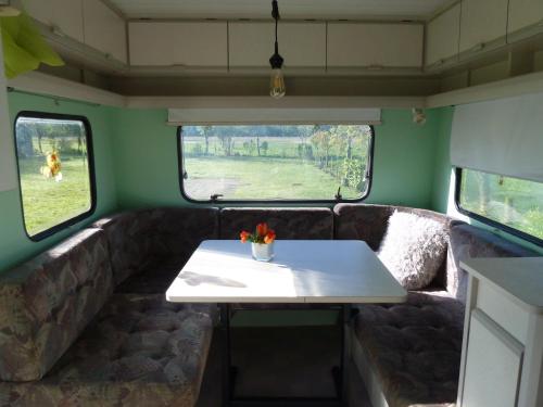 RouveenCaravan Vlinder的一张桌子,放在火车后面,有两个窗口